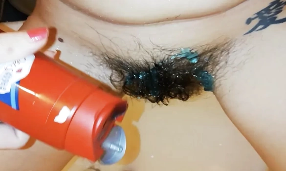 Женщина моет пизду с волосатым лобком и снимает это